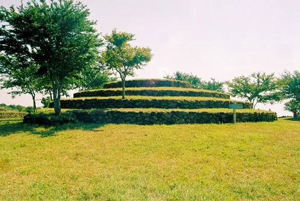 Pirámide circular de los Guachimontones con plataformas escalonadas de piedra sobre un área verde, Jalisco.