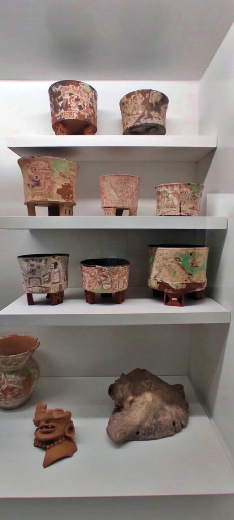 Repisa con vasijas de cerámica pintadas y objetos arqueológicos en una vitrina del Museo Anahuacalli.