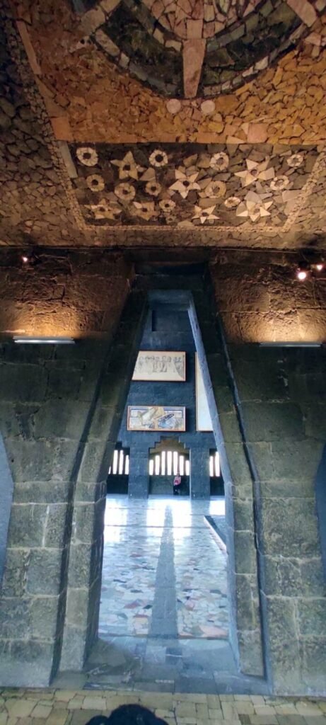 Gran arco y pasillo interior del Museo Anahuacalli con mosaico en el techo y luz al fondo.