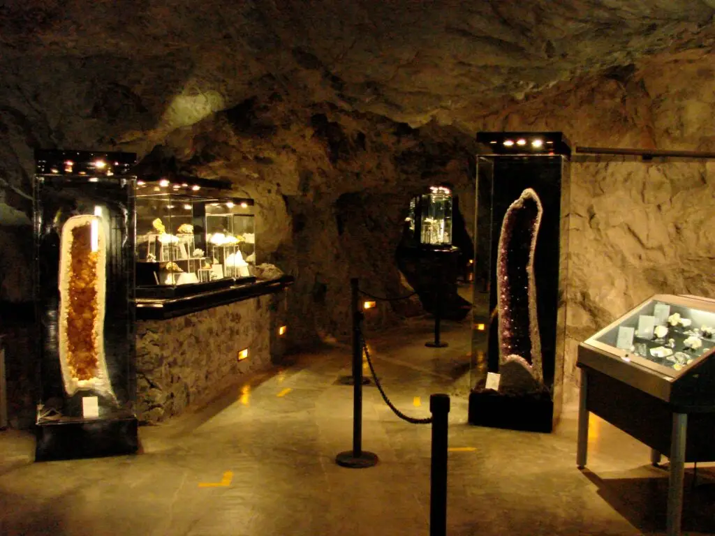 Sala museográfica subterránea de la Mina del Edén con exhibición de geodas y minerales en vitrinas.
