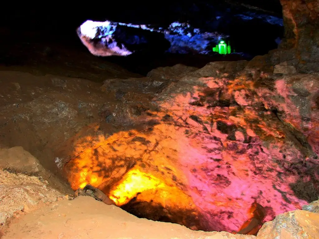 Galería profunda de la Mina del Edén iluminada con luces de colores que resaltan las vetas minerales.