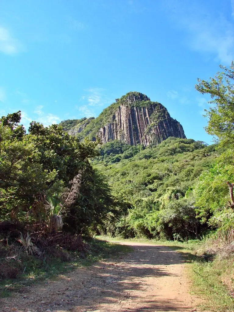 Camino de acceso a Quiahuiztlán con cerro de columnas basálticas rodeado de vegetación tropical.