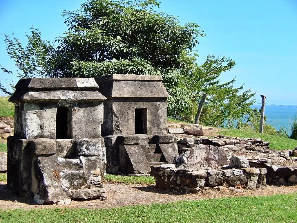 Templos funerarios prehispánicos de Quiahuiztlán construidos en piedra, alineados sobre una loma frente al mar.