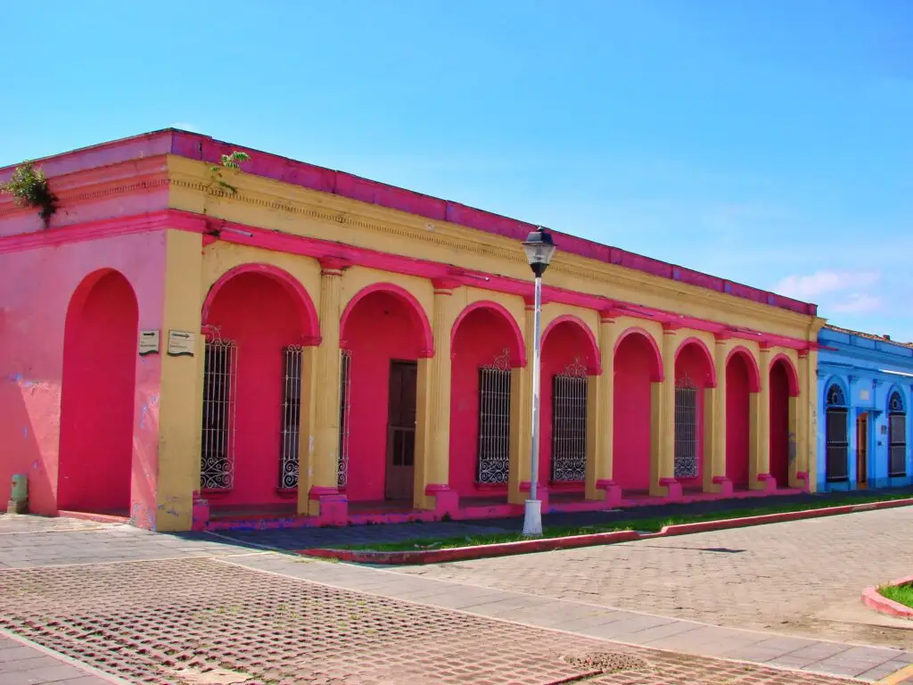 Fachada colonial de Tlacotalpan con arcos continuos en colores rosa y amarillo, edificio histórico del centro declarado Patrimonio de la Humanidad.