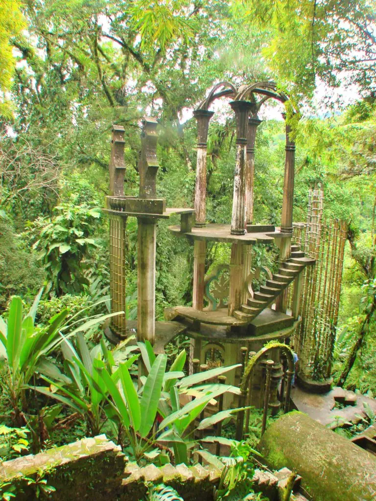Estructura surrealista de concreto con columnas y escaleras rodeada de vegetación tropical en el Jardín Surrealista de Xilitla.